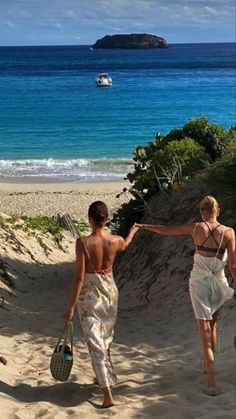 two women walking on the beach holding hands