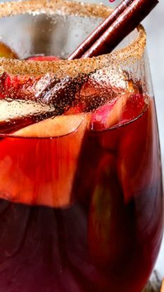 a close up of a drink in a glass with cinnamon stick sticking out of it