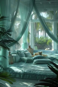 a bed with blue sheets and pillows in front of a window that has palm trees