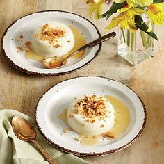 two white plates with dessert on them and flowers in vases behind them, one is empty