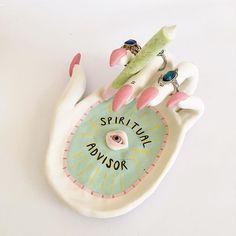 a ceramic figurine with pink and white nails on it