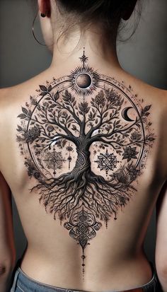 a woman's back with a tree tattoo on it