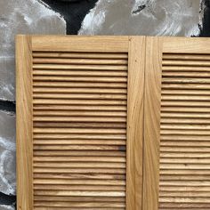 two wooden louvered doors on the side of a building