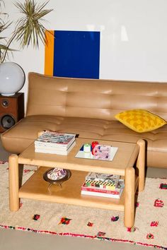 a brown leather couch sitting next to a wooden coffee table