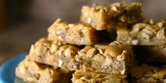 a blue plate filled with peanut butter and oatmeal bars stacked on top of each other