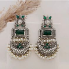 These beautiful statement emerald green dangler earrings will compliment any outfit! Made in high quality German silver, these are light weight and easy to wear.  For any queries, please feel free to contact us. Happy shopping! Elegant Green Danglers For Festive Occasions, Green Earrings With Latkans For Party, Green Chandbali Danglers For Party, Green Latkan Earrings For Party, Green Drop Earrings For Celebration, Elegant Green Chandbali Danglers, Festive Green Fusion Style Jhumkas, Green Fusion Style Party Earrings, Fusion Style Green Danglers For Party