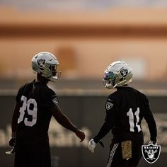 two oakland football players shaking hands on the field