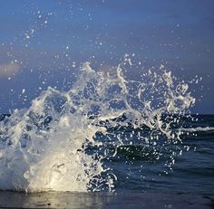 the water is splashing up on the beach