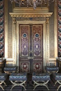 an ornately decorated room with two chairs and a chandelier