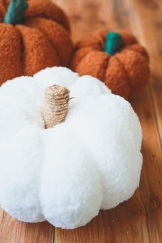 two pumpkins sitting on top of a wooden floor