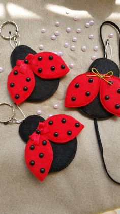 three red and black ladybug keychains on a table with polka dots