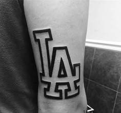 a man with a tattoo on his arm that has the letter l in it and is black and white