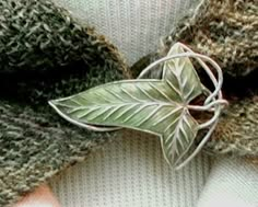 a green leaf is attached to the back of a sweater