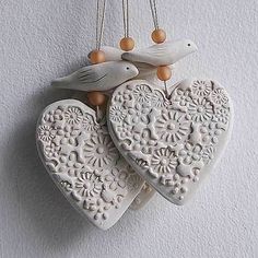 two heart shaped ceramic ornaments hanging on a wall