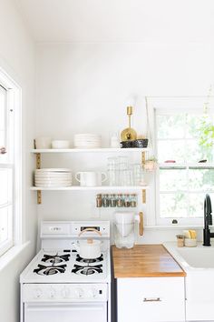 a white stove top oven sitting inside of a kitchen