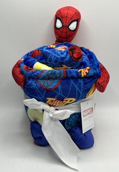 a spiderman stuffed animal sitting on top of a blue blanket