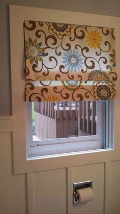 an open window with a flowered valance and matching blinds in front of it