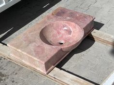 a stone sink sitting on top of wooden pallets