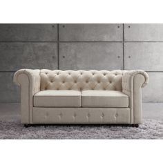 a white couch sitting on top of a carpeted floor next to a gray wall