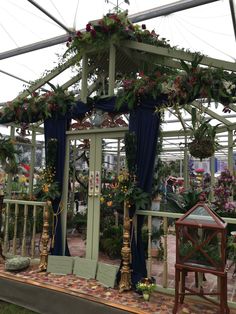 an outdoor gazebo decorated with flowers and greenery