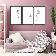 a living room with pink walls and two framed pictures on the wall, one has a flower