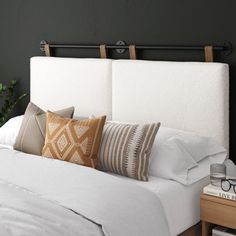 a white bed topped with lots of pillows