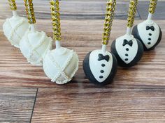 four cake pops decorated with black and white fondant, gold sequins and bow ties