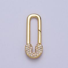 a gold colored metal pin with diamonds on it