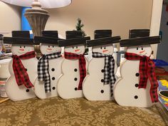 four snowmen with hats, scarfs and scarves are lined up in a row