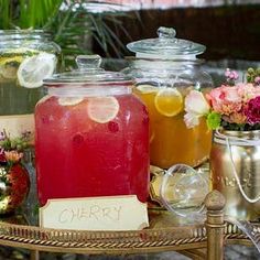 there are many different types of drinks on the table and in glass jars with labels