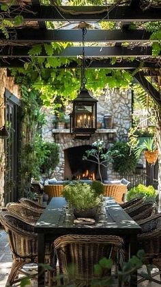 an outdoor dining area with wicker chairs, table and fire place in the background