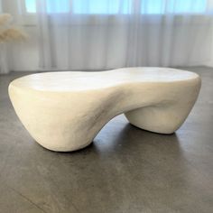 a white sculpture sitting on top of a wooden table