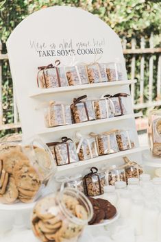 a table topped with lots of cookies on top of a white table covered in plastic containers