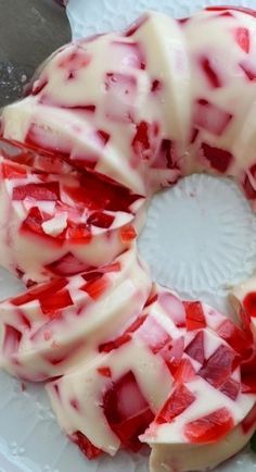 a cake with white icing and strawberries is on a plate next to a knife