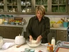 a woman in the kitchen mixing something in a bowl