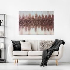 a living room with a white couch, black and white throw blanket and shelving unit