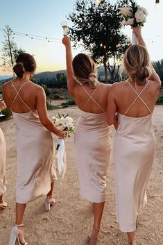 the bridesmaids are walking down the road with their bouquets in each hand