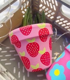 a pink flower pot with strawberries on it