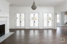 an empty living room with wood floors and white painted walls is pictured in this image