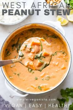 a spoon full of soup with rice and cilantro on the table next to it