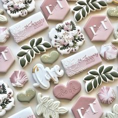 many decorated cookies are arranged on a table top with the words love spelled in white, pink and green