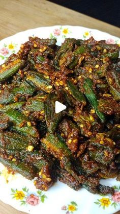 a plate filled with cooked okra on top of a wooden table