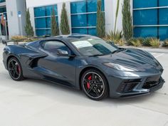 a gray sports car parked in front of a building