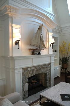 a living room with a fire place and a sailboat on the mantle