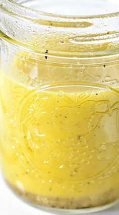 a jar filled with yellow liquid sitting on top of a table