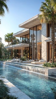 a large house with a pool in front of it and palm trees around the pool