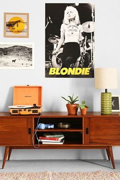 a living room with a wooden entertainment center and pictures on the wall above it that says blondie