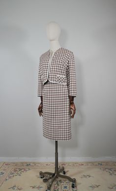 "Color: Brown & White  Label:  Joyce of Chicago  Material: Cotton Fits like: Modern Small  Condition: Excellent Condition  Timeless 1950s two piece cotton bolero jacket and pencil skirt set in a brown and white checkered pattern . The color presents beautiful and rich. Both the jacket and skirt are unlined. The jacket has no buttons buttons, but two small pockets on each side. Pencil skirt has zipper and button closure.  Specifications: -Jacket  Shoulder:15  \" Underarms:18  \" Arm length: 19\" Length:  18\" -Skirt Waist:12\"    Hips: 19 \" Length: 26\" --TERMS AND CONDITIONS: Each item is wrapped in acid free tissue paper to preserve and protect the garment/ item. Items are processed and shipped within 2-3 business days. Your satisfaction is our highest priority. Because of the age of an Retro Fitted Cotton Sets, Retro Fitted Skirt Suit, Retro Spring Daywear Sets, Vintage Cotton Sets For Daywear, Vintage Workwear Sets For Spring, Retro Spring Workwear Sets, Vintage Sets For Spring Daywear, Retro Workwear Sets For Spring, Fitted Cotton Sets For Daywear