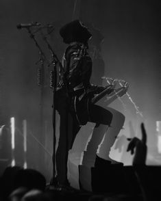 a man standing on top of a stage holding a guitar