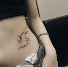 a woman's stomach with a fish tattoo on her belly and the bottom part of her lower back